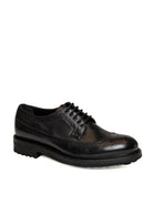 Vista tre quarti di derby brogue in pelle nera Jerold Wilton con punta traforata.